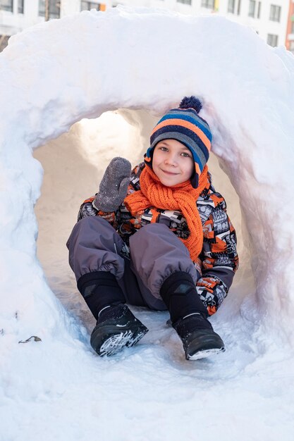 Cute boy playing in the snow castle