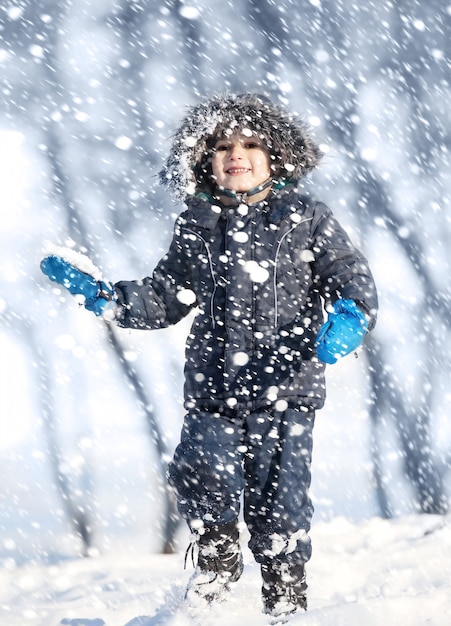 Cute boy playing with snow