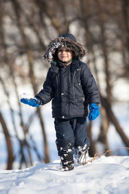 Cute boy playing with snow