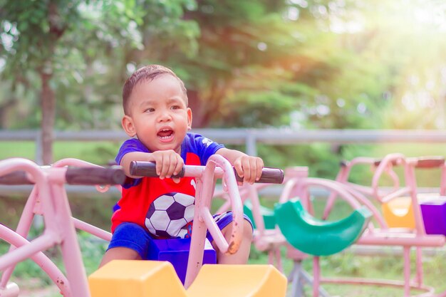 Foto un ragazzo carino che gioca con un giocattolo nel parco giochi.