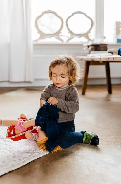 Фото Милый мальчик играет с игрушками дома.
