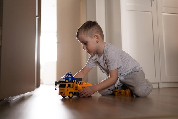 Photo cute boy playing with wooden railway at the home