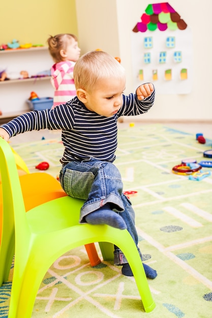 Cute boy plays with toys in the kindergarten