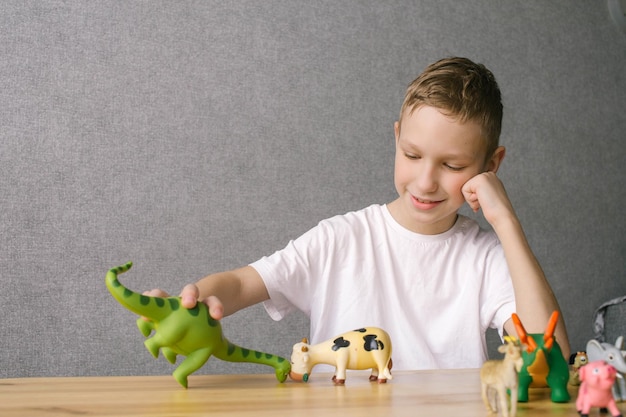 A cute boy put animal figures on the table a portrait of a child