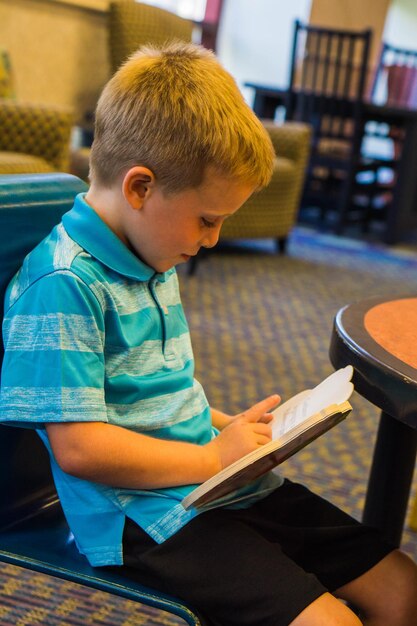Cute boy reading menu at restaurant