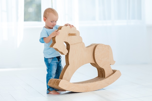 Cute boy rocking on wooden handmade horse