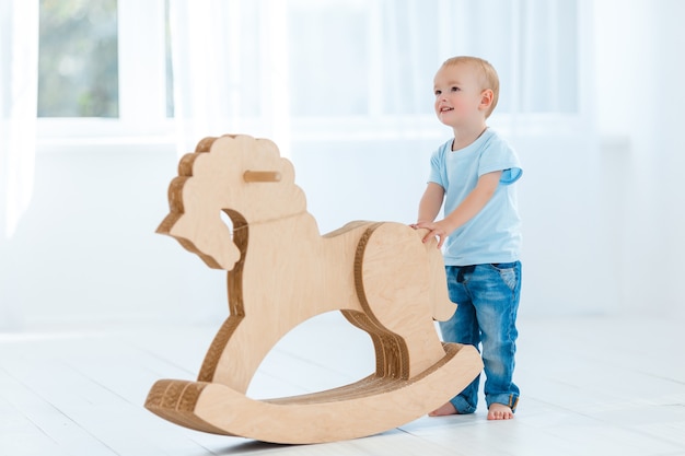 Cute boy rocking on wooden handmade horse