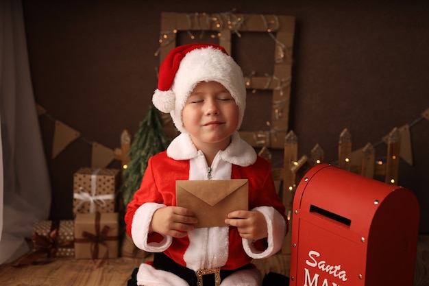 cute boy in Santa costume sends a letter to Santa Claus