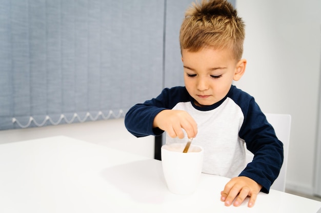 Photo cute boy sitting on table