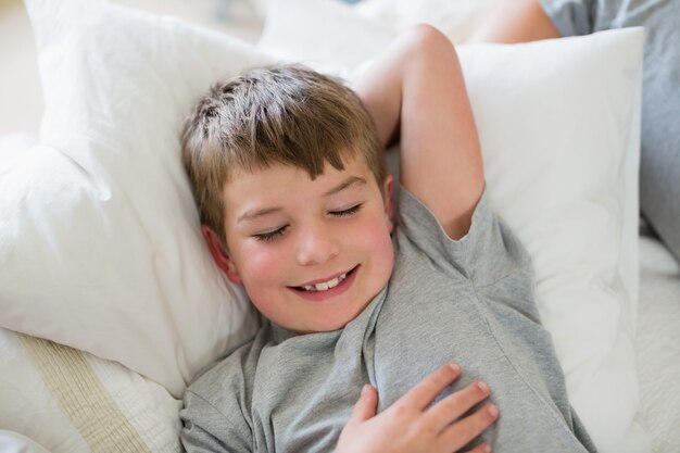 Ragazzo sveglio che dorme sul letto in camera da letto