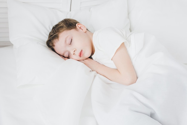 Cute boy sleeps in the morning in bed 