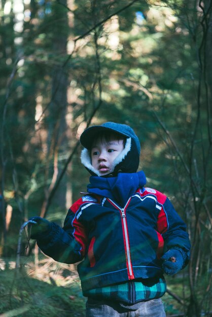 Photo cute boy standing in forest