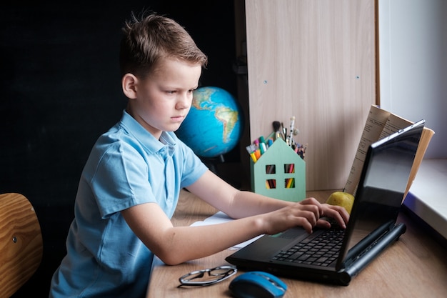 Cute boy takes an online education course at home