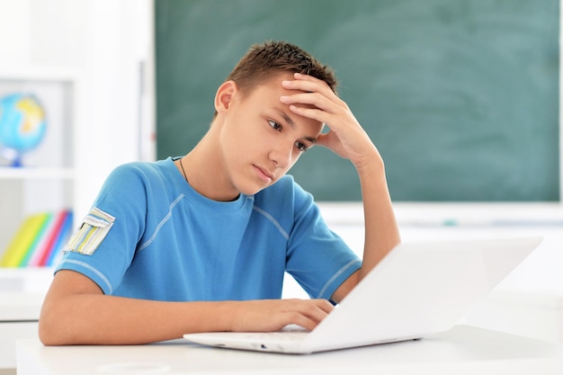 Cute boy using laptop in room