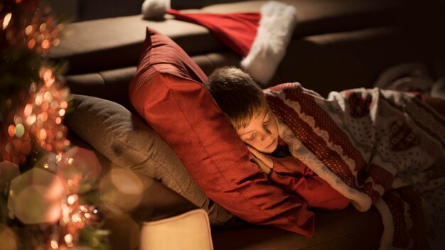 Photo cute boy waiting for santa and sleeping on the sofa