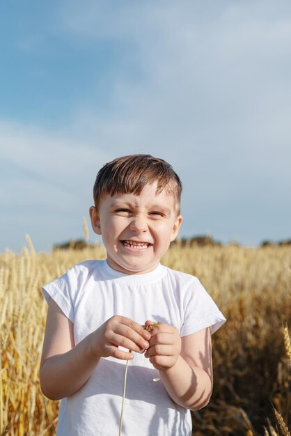 Cute boy walking across the wheat field making funny faces