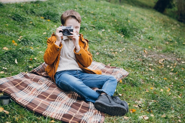 Cute boy walks and poses in a colorful autumn Park