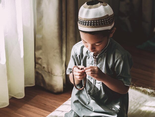 Photo cute boy wearing hat at home