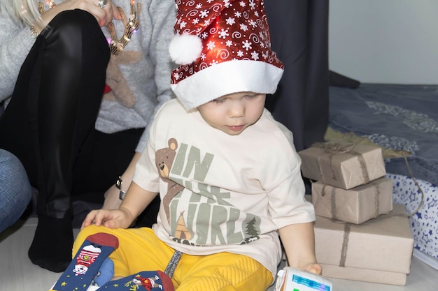 Cute boy wearing santa hat playing with toy