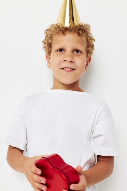 Cute boy with a cap on his head a gift box in the shape of a heart