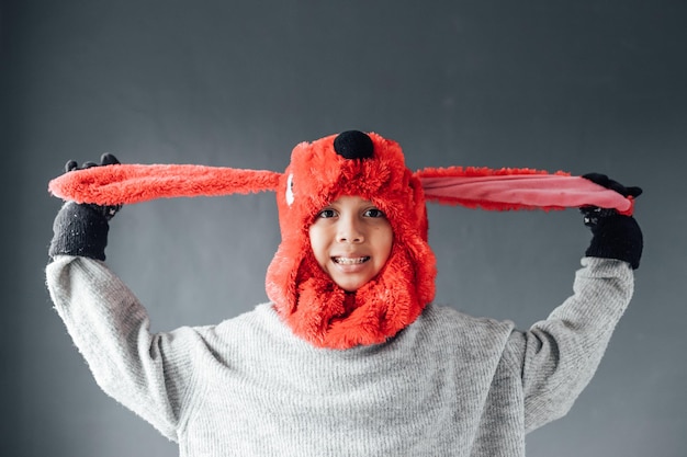 Photo cute boy with happy expression wearing winter clothes welcomes winter season