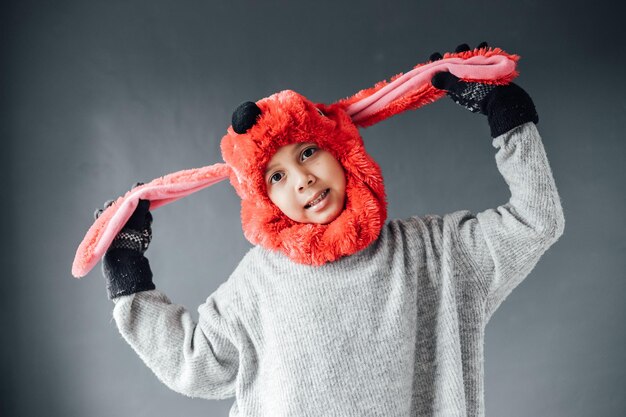 Cute boy with happy expression wearing winter clothes welcomes winter season