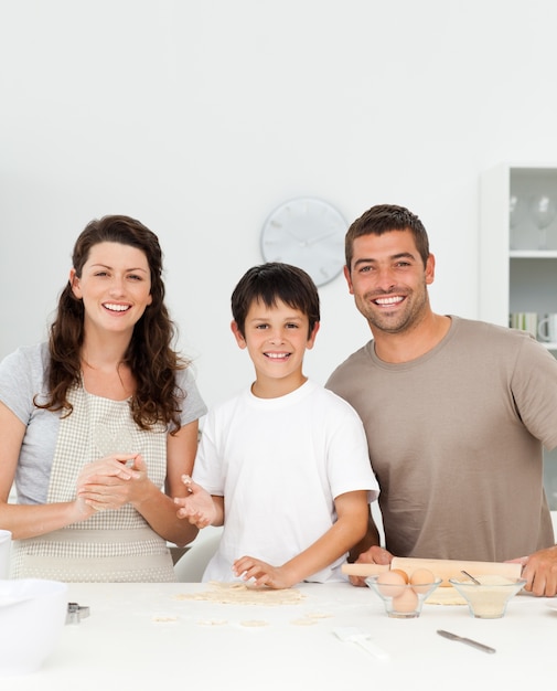 Cute boy with his parents in his kitchen