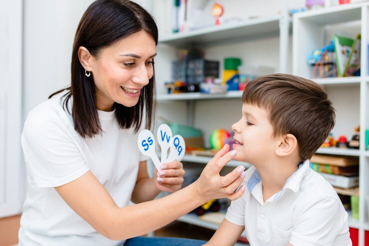 Photo a cute boy with a speech therapist is taught to pronounce the letters, words and sounds.