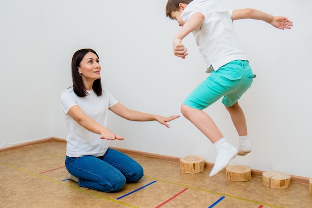 A cute boy with a speech therapist is taught to pronounce the letters words and sounds