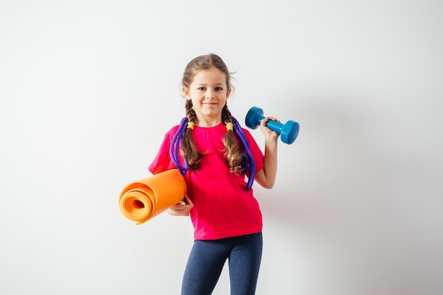 Cute boy with sport equipment sitting on a floor