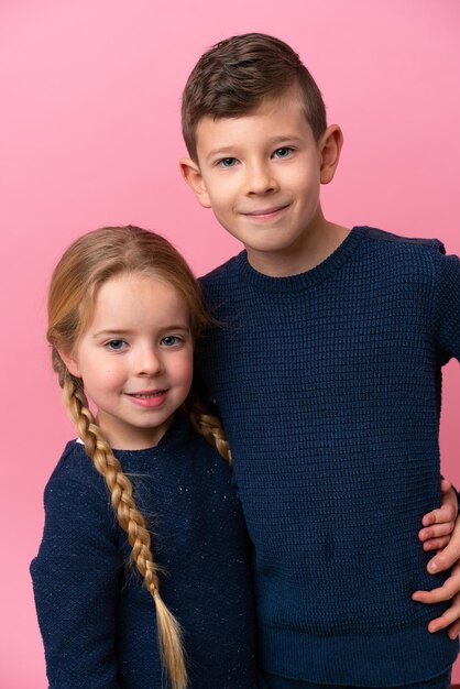 Photo cute brothers over isolated pink background