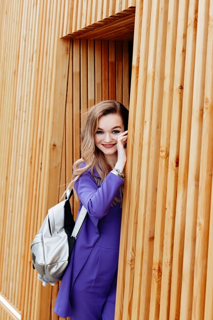 A cute brown-haired woman with a happy expression is walking around the city on a warm sunny day