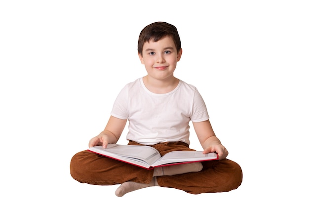 A cute brunette boy holding a large open book