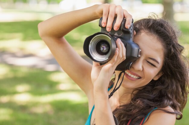 彼女のカメラで写真を撮るかわいいブルネットの女性