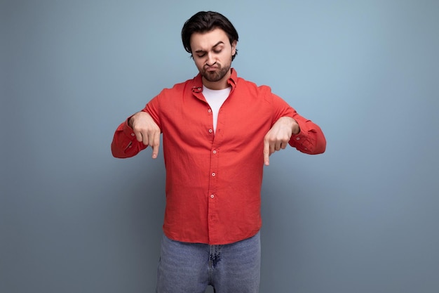 Cute brutal young brunette man showing thumbs down