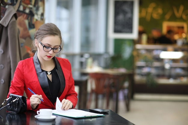 Cute businesswoman goes to a business meeting in a cafe