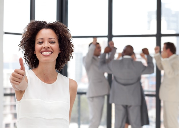 Cute businesswoman with her thumb up to camera