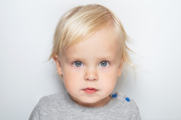 Photo cute caucasian baby boy in a gray t-shirt on the white background portrait