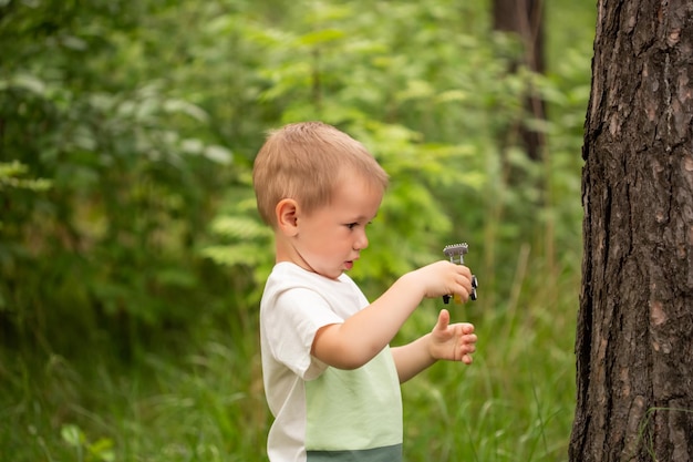 Cute Caucasian boy in the forest against the background of grass