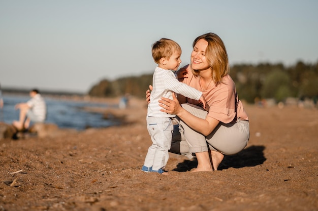 Cute Caucasian boy and happy mother together at coast