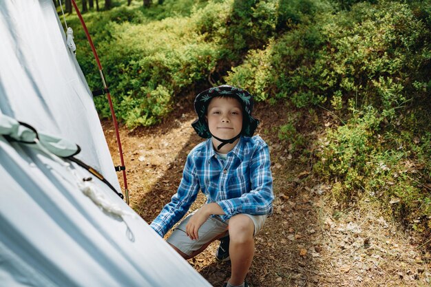 cute caucasian boy putting up a tent Family camping concept