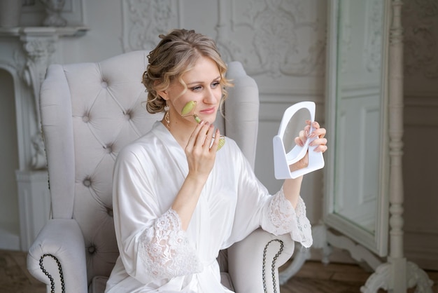 Cute caucasian woman is doing an antiwrinkle facial massage with special