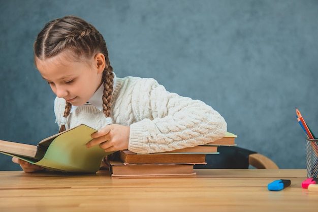 Cute charming and adorable girl is reading a book with a great interest in it Girl wants to read it in a one gulp