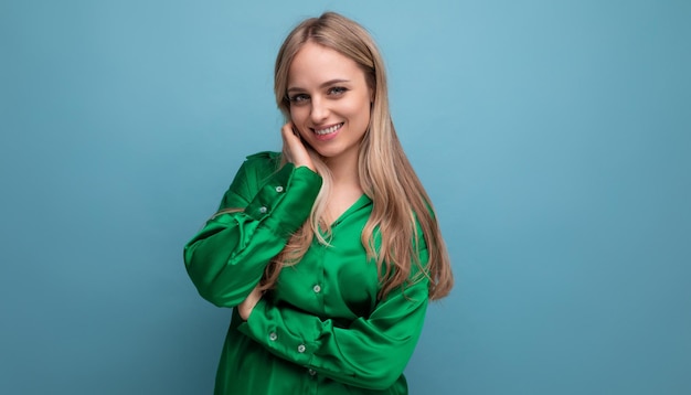 Cute charming young adult woman posing on blue background with empty space