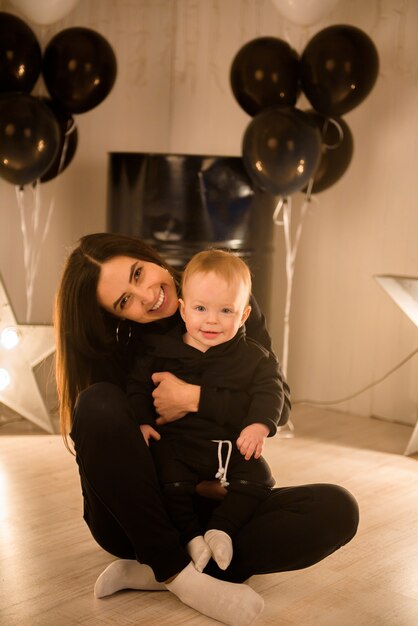 Cute cheerful child with mother play indoors.