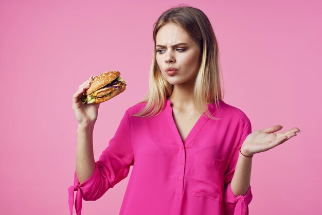 핑크 셔츠 햄버거 음식 다이어트에 귀여운 쾌활한 여자 고품질 사진