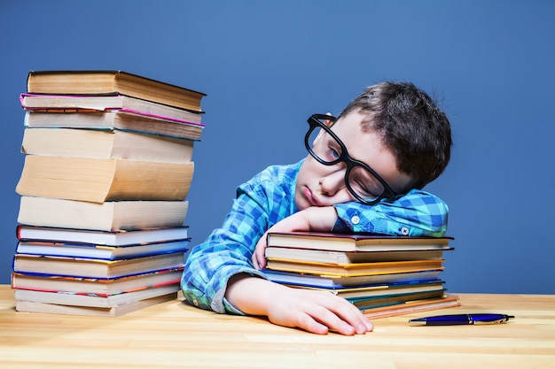 Cute child asleep at the desk in school library