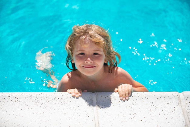 Cute child boy swim in swimming pool summer water background with copy space Funny kids face Kid playing outdoors Summer vacation and healthy lifestyle concept