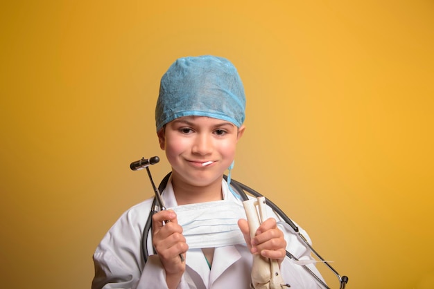 Cute child in doctor coat with stethoscope on color background Space for text