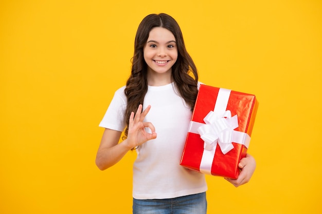 Cute child girl congratulate with valentines day giving romantic gift box Present greeting and gifting birthday concept Happy teenager positive and smiling emotions of teen girl